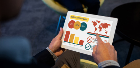 Digital composite image of business presentation with charts and text against businessman using digital tabletの写真素材