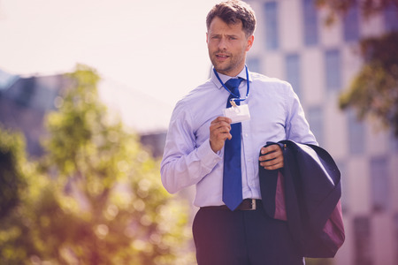 Portrait of handsome businessman showing identity card badgeの写真素材