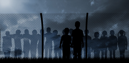 Silhouette boys holding hands against blue and orange sky with cloudsの写真素材