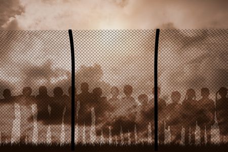 Digital composite image of fence against blue sky with white cloudsの写真素材