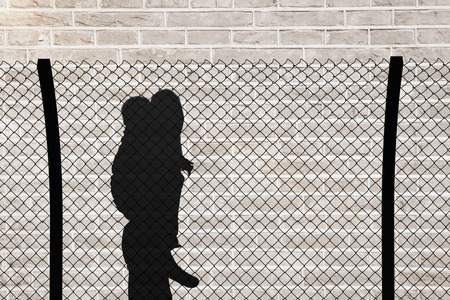 Portrait of mother giving piggyback ride against brick wall backgroundの写真素材