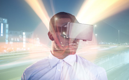 Man wearing virtual reality simulator against white background against illuminated city street