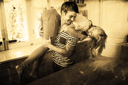 Grey background against handsome man carrying wifeの写真素材