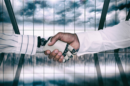 Businessman and robot shaking hands against room with large window looking on cityの写真素材