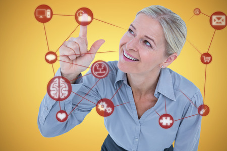 Smiling businesswoman pointing against yellow vignetteの写真素材