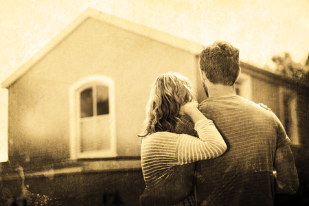 Grey background against couple standing against houseの写真素材