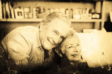 Grey background against portrait of romantic senior couple hugging