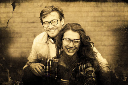 Grey background against portrait of happy young couple in spectaclesの写真素材