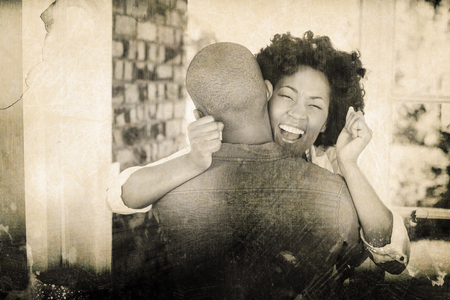 Grey background against happy couple embracing and cheering