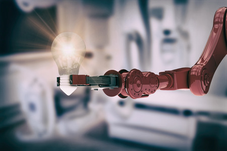 Composite image of robotic arm holding light bulb against modern examing roomの写真素材