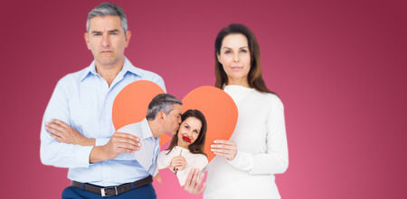 Portrait of wife holding rose with husband against red vignetteの写真素材