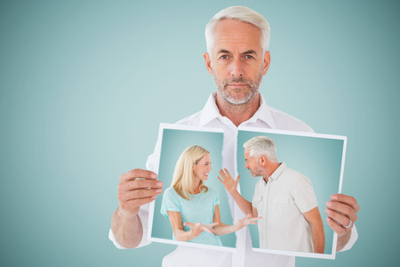 Unhappy couple having an argument  against blue backgroundの写真素材