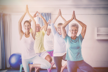 Instructor performing yoga with seniors during sports classの写真素材