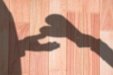 Woman handing man a paper heart against overhead shot of deskの写真素材