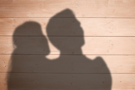 Happy couple looking upwards against overhead of wooden planksの写真素材
