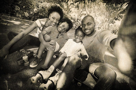 Grey background against portrait of happy family at parkの写真素材