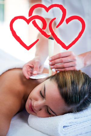 woman receiving ear candle treatmentの写真素材