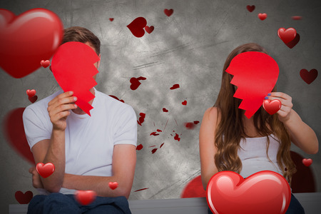 Couple holding broken heart against love heart pattern 3Dの写真素材