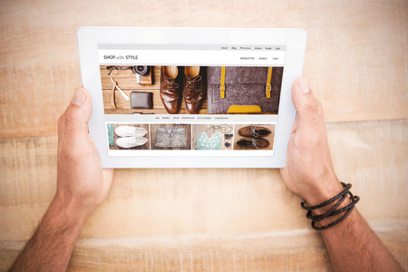 shop with style homepage against hands holding blank screen tabletの写真素材
