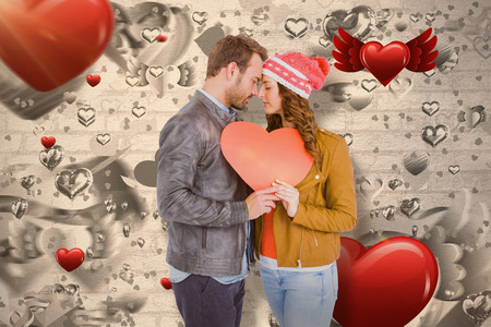 Romantic young couple holding heart shape paper against love heart pattern 3dの写真素材