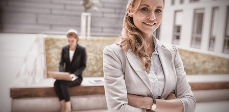 Portrait of businesswoman standing with arms crossed in office premises