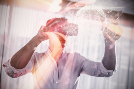 Global technology background in green against businessman using an oculusの写真素材