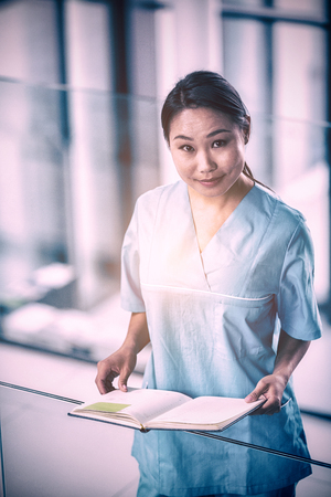 Portrait of a nurse holding a diary in hospitalの写真素材