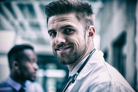 Portrait of smiling doctor standing in hospitalの写真素材
