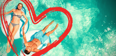 couple relaxing on lilosの写真素材