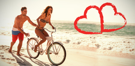 Print against couple riding bicycle at beachの写真素材
