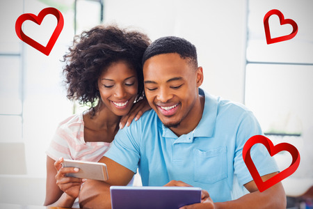 heart against couple using mobile phone and digital tablet 3dの写真素材