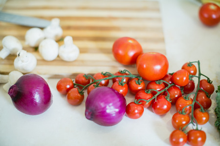 Cherry tomato, onion and mushroom on kitchen worktop at homeの写真素材