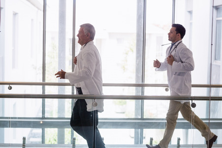Two doctors running in hospital corridor