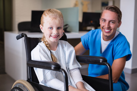 Portrait of smiling doctor and disable girl in hospital corridorの写真素材