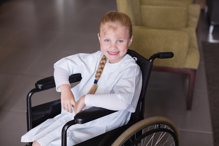 Portrait of smiling girl patient sitting on a wheelchair in hospitalの写真素材