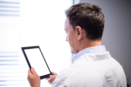Male doctor using digital tablet in clinic