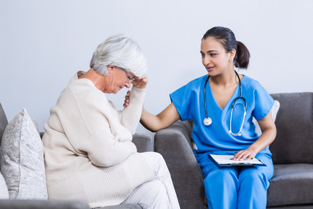 Doctor consoling senior patient in clinicの写真素材