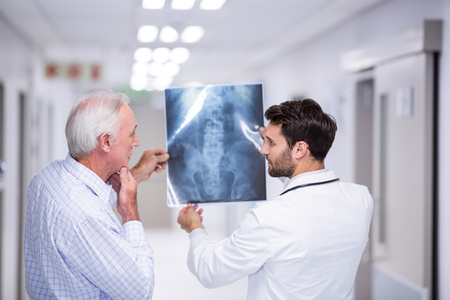 Doctor discussing x-ray with patient in corridor of hospital
