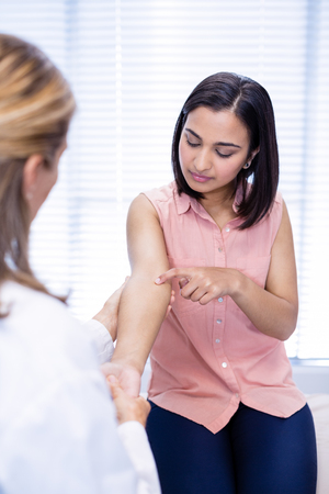 Doctor examining patient in clinicの写真素材
