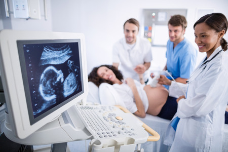 Doctor doing ultrasound scan for pregnant woman in hospitalの写真素材