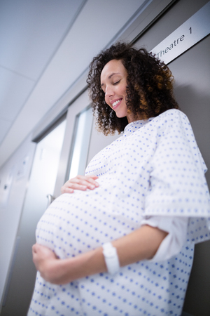 Pregnant woman standing in corridor of hospitalの写真素材