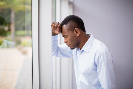 Worried and stressed businessman with hand on head at conference centreの写真素材