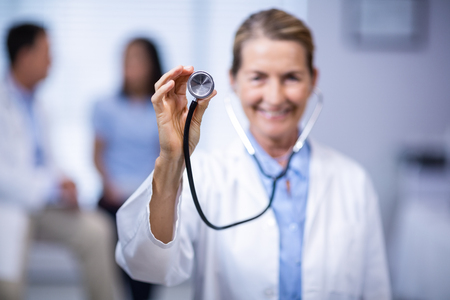 Female doctor holding stethoscope in clinicの写真素材