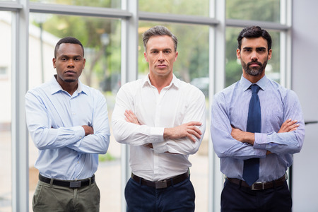 Portrait of business executives standing with arms crossedの写真素材