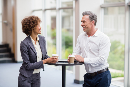 Business executives interacting each other while having coffee at conference centreの写真素材