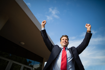Excited businessman cheering outside the conference centreの写真素材