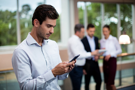 Male business executive using mobile phone at conference centerの写真素材