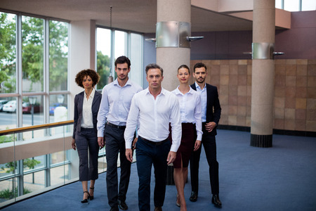 Portrait of business executives walking in a conference center lobby