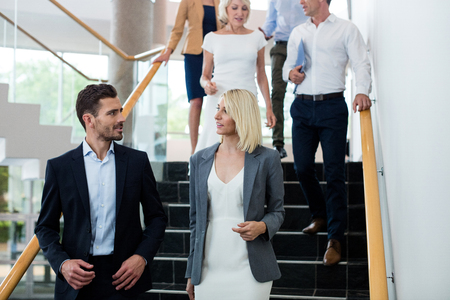 Business executives walking down the stairs at conference centerの写真素材