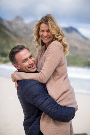 Romantic mature man holding mature woman on beachの写真素材
